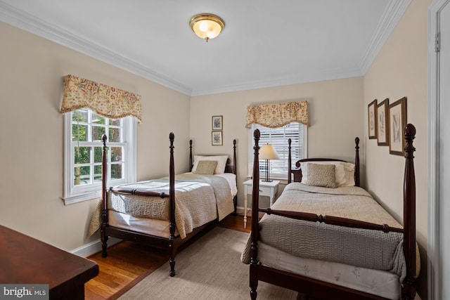 bedroom with baseboards, ornamental molding, and wood finished floors