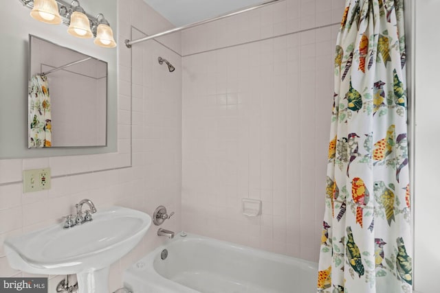 bathroom with shower / bath combo and a sink