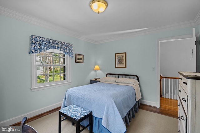 bedroom with crown molding, baseboards, and wood finished floors