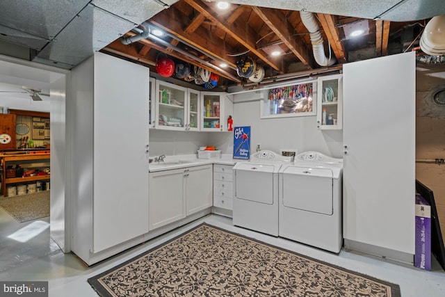 laundry area featuring independent washer and dryer, a sink, and cabinet space