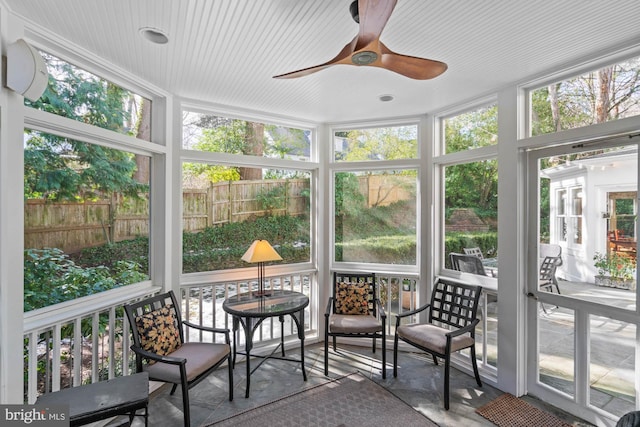 sunroom / solarium with a ceiling fan and a wealth of natural light