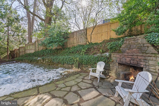 view of patio featuring an outdoor stone fireplace and a fenced backyard