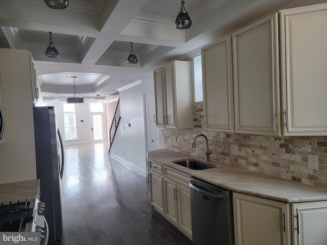 kitchen featuring a sink, ornamental molding, appliances with stainless steel finishes, cream cabinetry, and dark wood finished floors