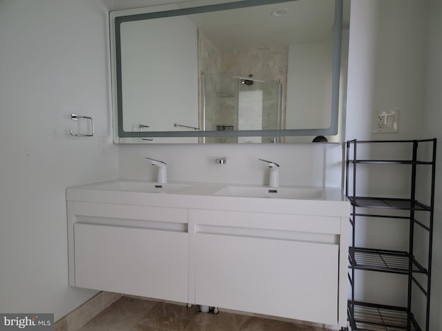 bathroom with a stall shower, a sink, and double vanity