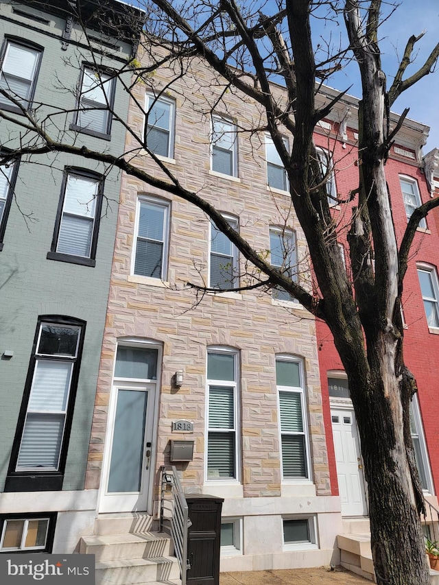 townhome / multi-family property featuring stone siding