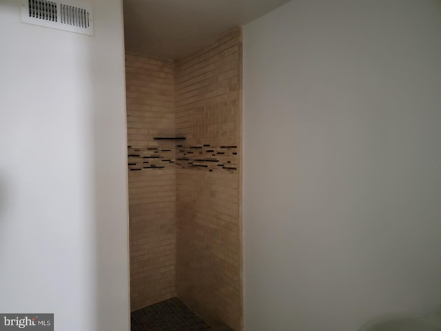 bathroom featuring visible vents and tiled shower