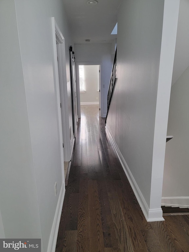 hallway with dark wood-style floors and baseboards