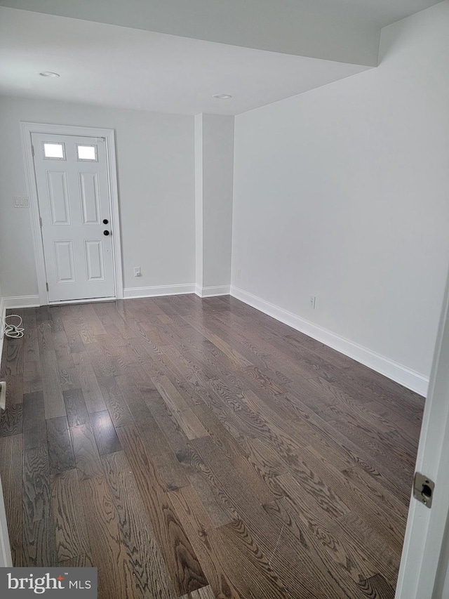 entrance foyer with dark wood-style flooring and baseboards