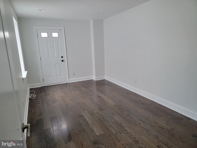 foyer featuring dark wood-style flooring and baseboards