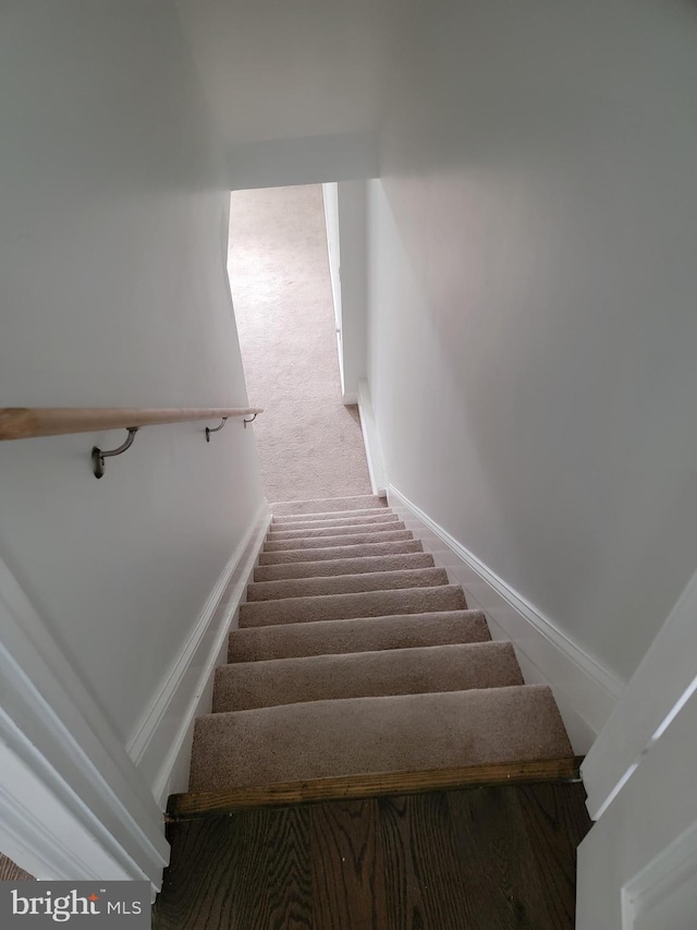 staircase featuring carpet and baseboards