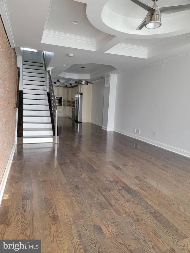 interior space with dark wood-style floors, crown molding, stairway, brick wall, and baseboards