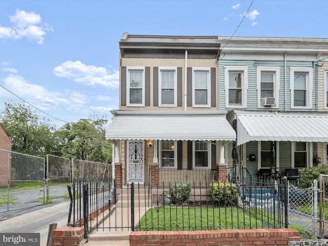 view of property with a fenced front yard, cooling unit, a gate, and covered porch