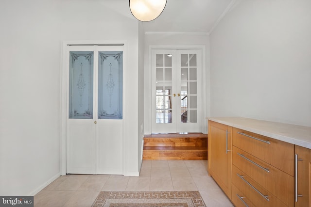 foyer entrance with light tile patterned floors, french doors, and crown molding