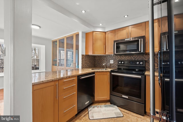 kitchen featuring tasteful backsplash, stainless steel microwave, electric range, freestanding refrigerator, and dishwasher