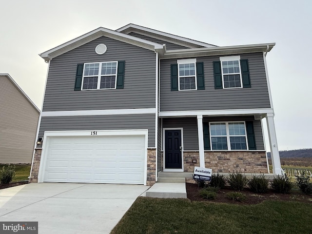 view of front of house with stone siding, driveway, and an attached garage