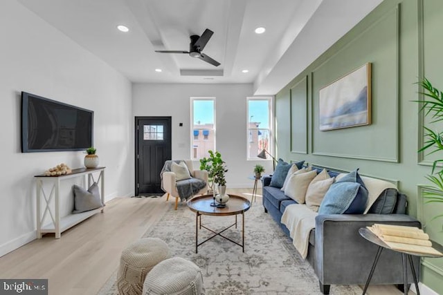 living room featuring a tray ceiling, ceiling fan, recessed lighting, and wood finished floors