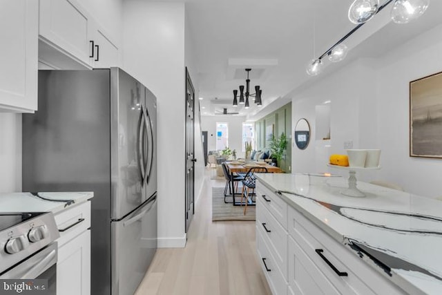 kitchen with white cabinets, light stone countertops, stainless steel appliances, light wood-style floors, and pendant lighting