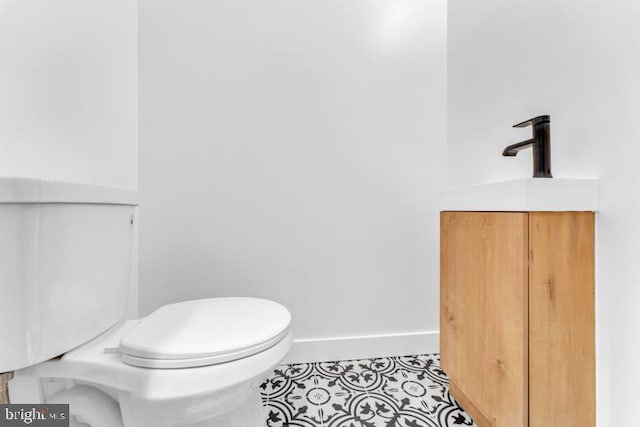 bathroom featuring tile patterned flooring, toilet, and baseboards