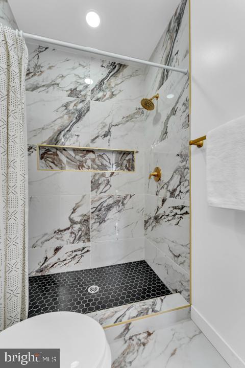 bathroom with a marble finish shower, baseboards, toilet, marble finish floor, and recessed lighting