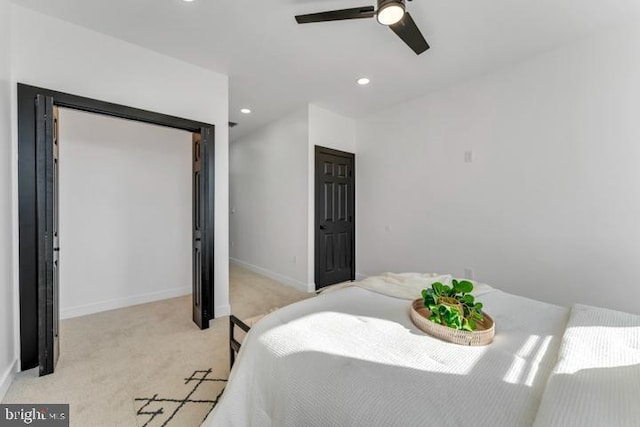 bedroom with ceiling fan, recessed lighting, light colored carpet, baseboards, and a closet