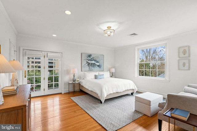 bedroom with ornamental molding, light wood finished floors, multiple windows, and visible vents