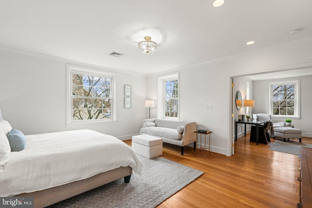 bedroom with light wood-type flooring, baseboards, and crown molding