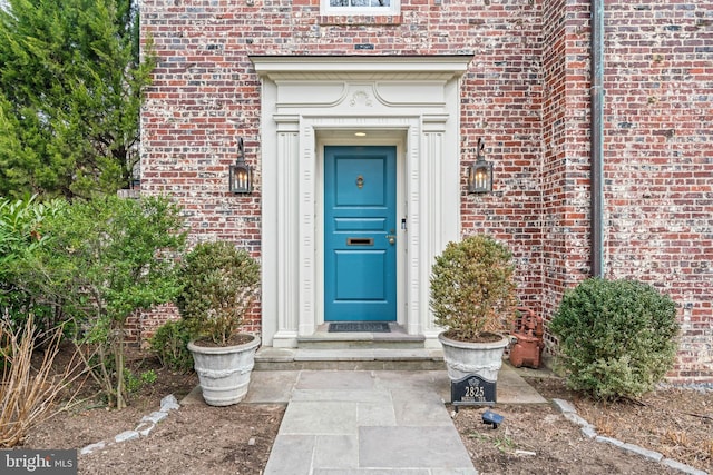 entrance to property featuring brick siding