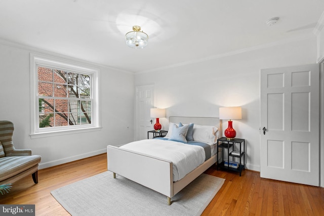 bedroom with light wood-style flooring, baseboards, and ornamental molding