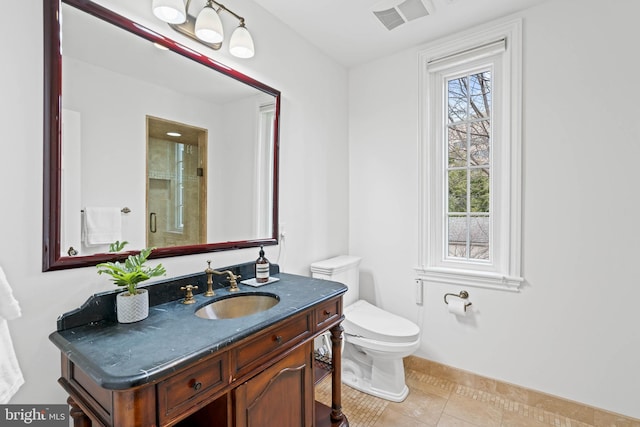 bathroom with toilet, vanity, visible vents, tile patterned floors, and a stall shower