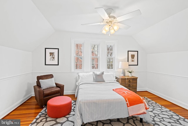 bedroom featuring ceiling fan, vaulted ceiling, baseboards, and wood finished floors