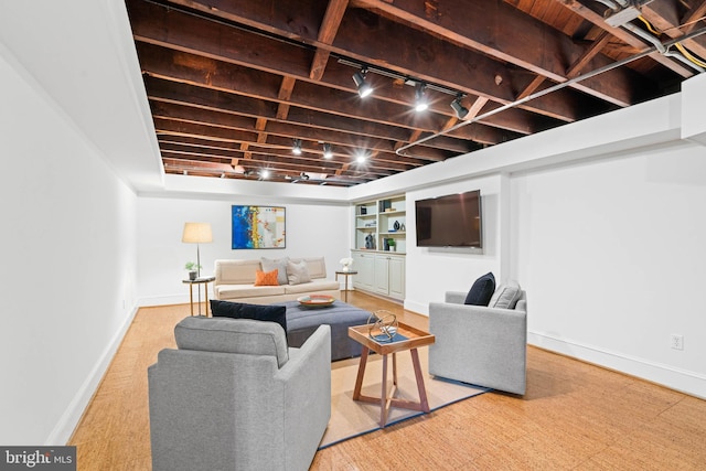 living room featuring rail lighting and baseboards