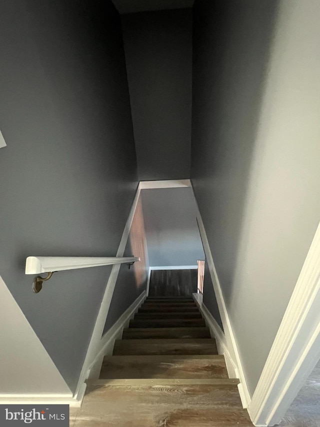 stairway with baseboards and wood finished floors