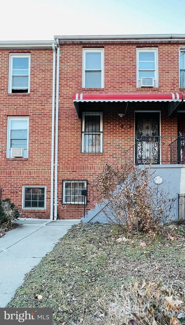 townhome / multi-family property with brick siding and cooling unit