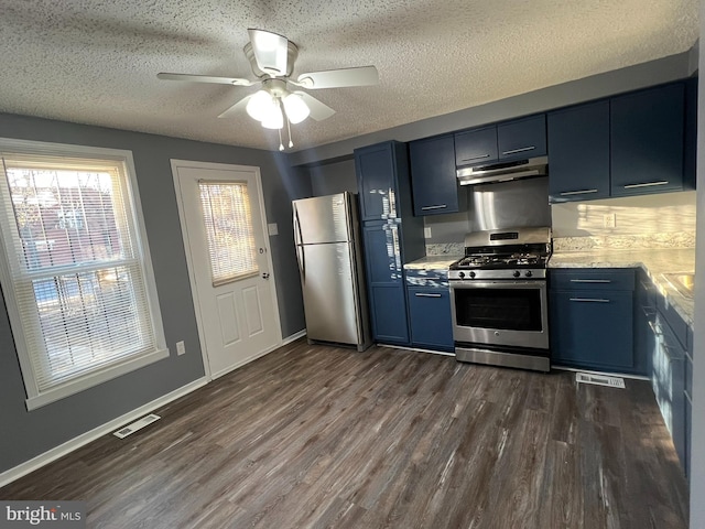 kitchen featuring visible vents, dark wood finished floors, under cabinet range hood, stainless steel appliances, and blue cabinetry