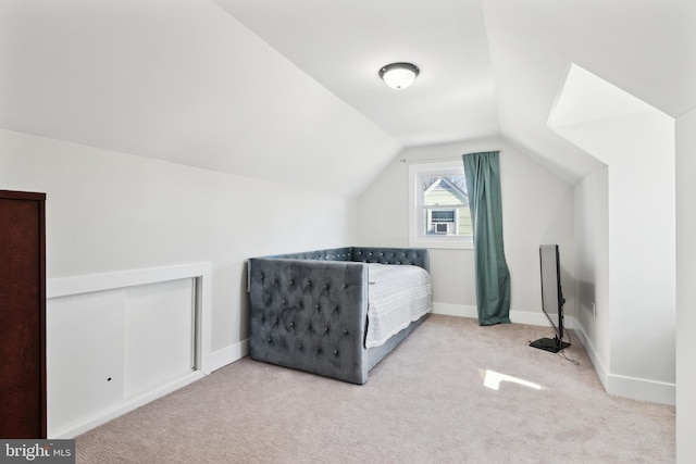 bedroom with vaulted ceiling, carpet floors, and baseboards