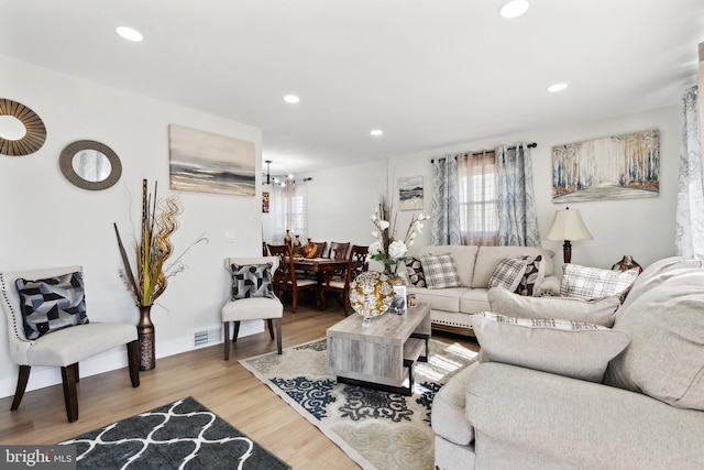 living room with visible vents, wood finished floors, and recessed lighting