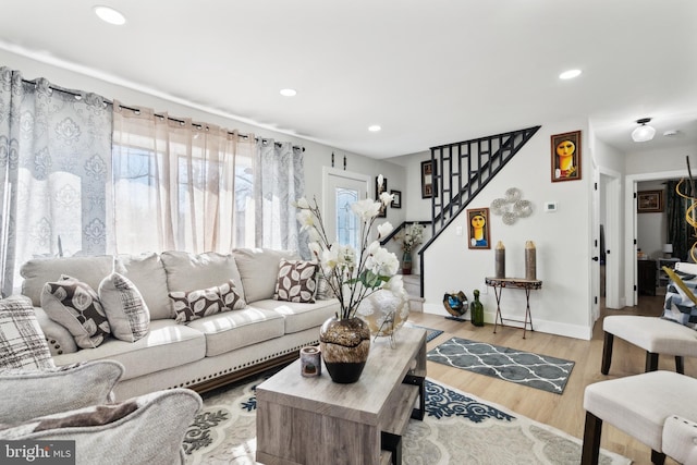 living room featuring baseboards, stairway, wood finished floors, and recessed lighting