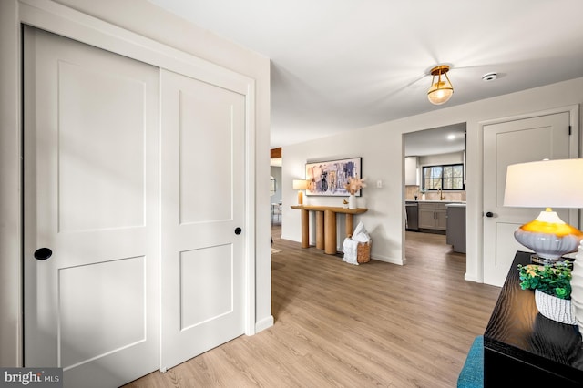 hallway with light wood finished floors and baseboards