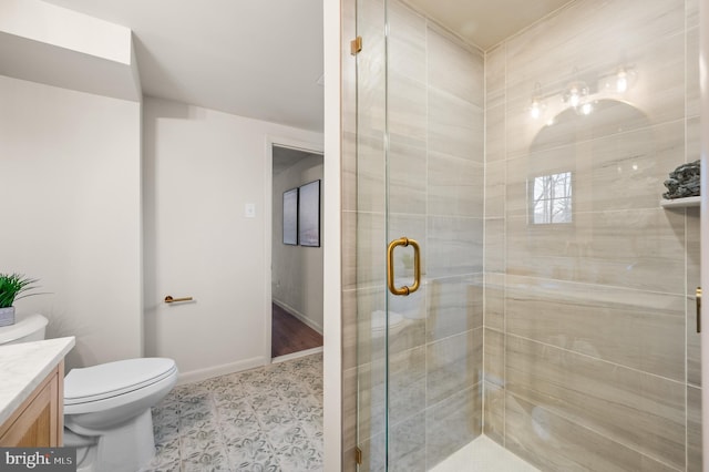 full bathroom featuring toilet, a stall shower, vanity, and baseboards