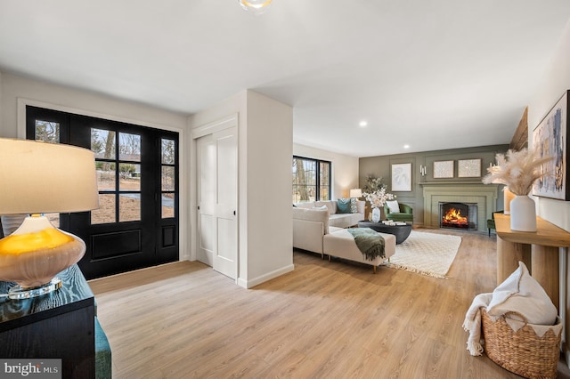 entryway with recessed lighting, a brick fireplace, baseboards, and light wood finished floors