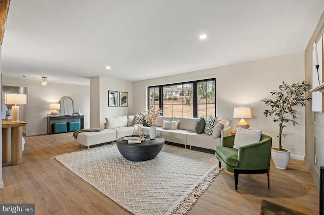 living area featuring baseboards, light wood finished floors, and recessed lighting