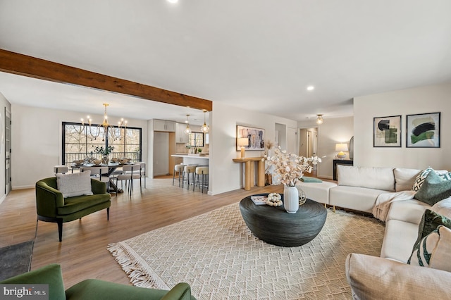 living area with a chandelier, recessed lighting, baseboards, light wood-type flooring, and beamed ceiling