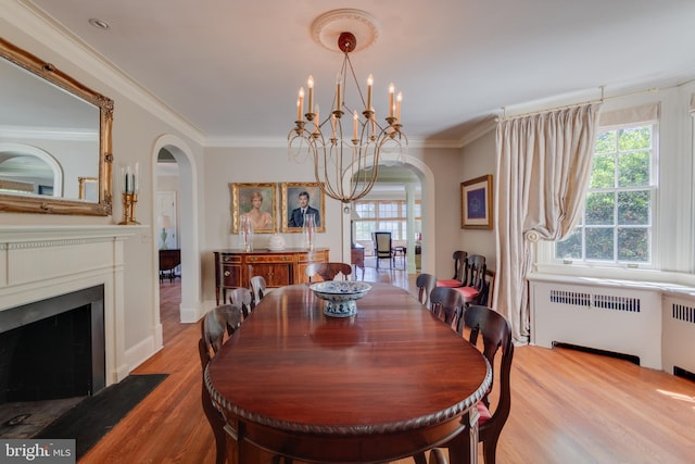 1911 Belle Haven Rd, Alexandria, VA 22307 - dining area featuring arched walkways, radiator, a chandelier, wood finished floors, and crown molding