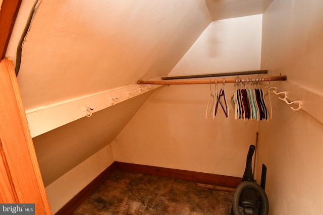 walk in closet featuring lofted ceiling and dark carpet