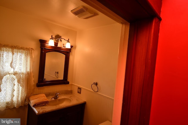 bathroom featuring a wainscoted wall and vanity