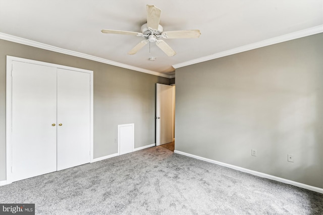 unfurnished bedroom with carpet floors, a ceiling fan, baseboards, a closet, and crown molding