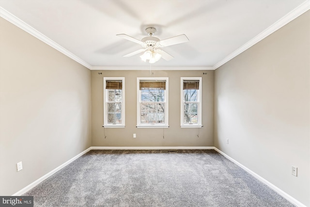 carpeted empty room with ceiling fan, crown molding, and baseboards