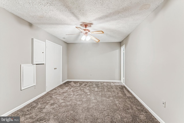 empty room featuring carpet flooring, ceiling fan, a textured ceiling, and baseboards