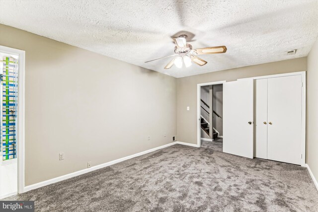 unfurnished bedroom with carpet, a closet, visible vents, a ceiling fan, and baseboards