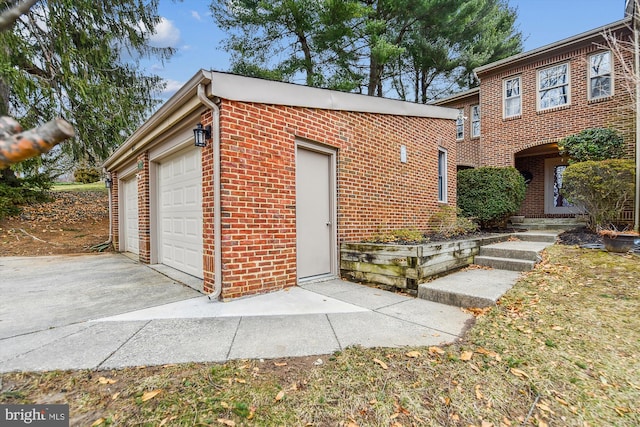 view of front facade featuring brick siding, driveway, and an attached garage